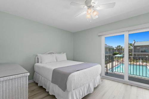 1 dormitorio con 1 cama y balcón con piscina en Gulf Winds #25 en Destin