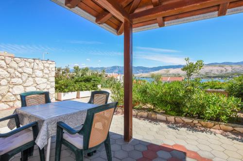 a table and chairs on a patio with a view at APARTMANI MARIJA LJUBICA in Pag