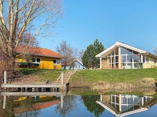 a house with a dock next to a body of water at 6 person holiday home in Otterndorf in Otterndorf