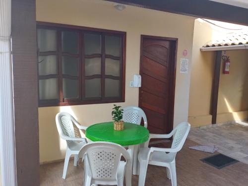 un tavolo verde con sedie in una stanza di Casa da Celia 02 ad Arraial do Cabo