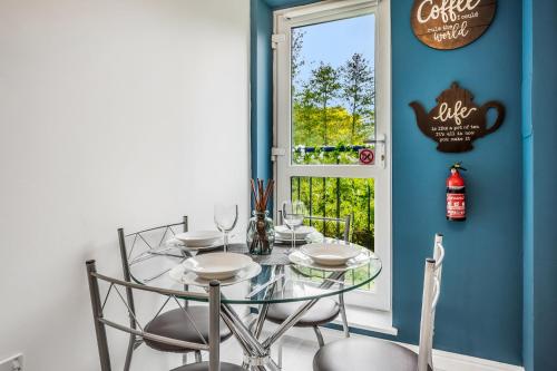 a dining room with a glass table and chairs at Saughton Suite in Edinburgh