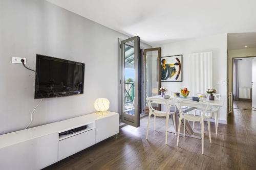 un salon blanc avec une table et une télévision dans l'établissement Appartement Barbeau - Welkeys, à Biarritz