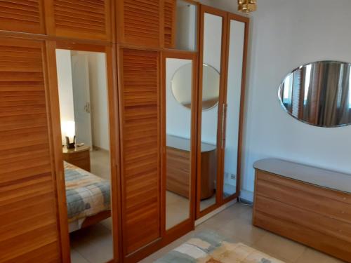 a bathroom with wooden cabinets and a mirror at Nice Furnished apartment in Amman