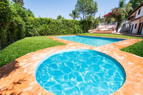 a swimming pool in the yard of a house at La Diligencia Cabañas Campestres in Morelia