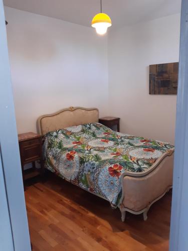 a bedroom with a bed with a floral bedspread at L'ère du temps in Manheulles