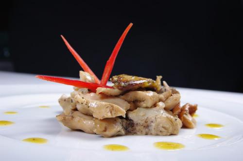 a plate of food with meat and red peppers on it at Hotel Boutique Bodegas De Arnes - Adults Only in Graus