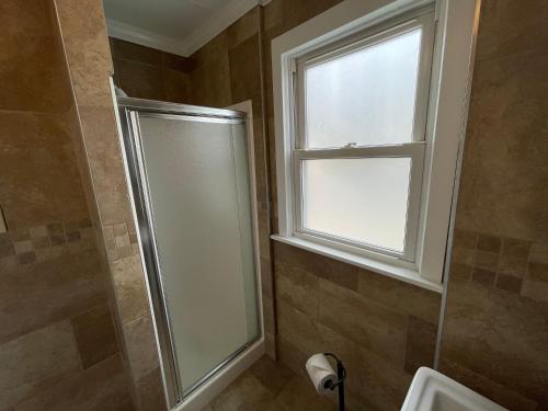a shower stall in a bathroom with a window at Buttercup Suites Wildwood Crest Beach in Wildwood Crest