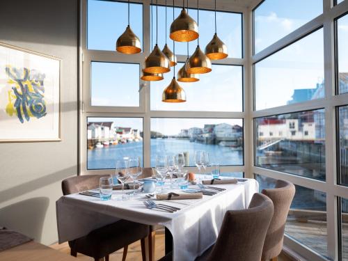 a dining room with a table and a large window at Villa Bryggekanten - by Classic Norway Hotels in Henningsvær