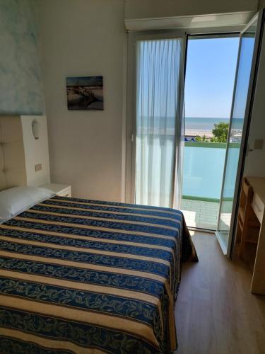 a bedroom with a bed with a view of the ocean at Costa del Sole Only Room in Milano Marittima