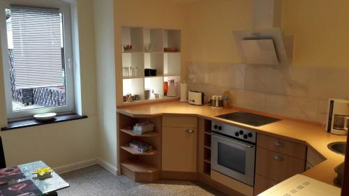 a kitchen with a stove and a sink and a window at Willkommen im Kalletal in Kalletal