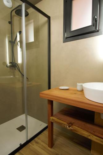 une salle de bain avec une douche en verre et un lavabo dans l'établissement les jardins de la sud, à Lacanau