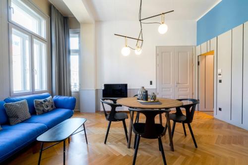 uma sala de estar com um sofá azul e uma mesa em Vienna Residence, City Hall - Parliament em Viena