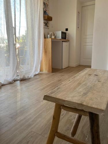 una mesa de madera en una habitación con cocina en La Petite Mer, en Riantec
