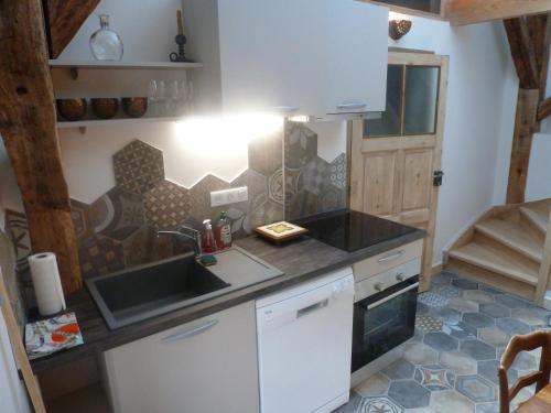 a kitchen with a sink and a counter top at Au Cheval Blanc - appartements et chambres d'hôtes in Albertville