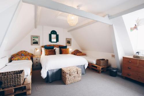 a attic bedroom with two beds and a dresser at The Old Store Guest House in Chichester