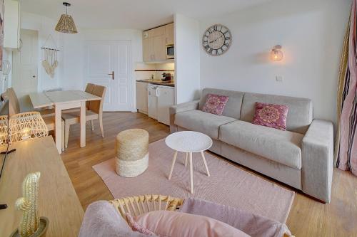 un salon avec un canapé et une table dans l'établissement IMMOGROOM - 2 Rooms renovated - Pool - Terrace - Garden - Parking -, à Cannes