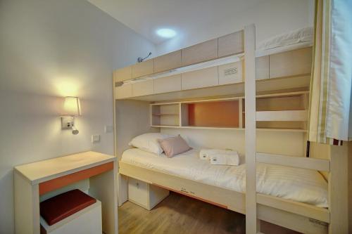 - une petite chambre avec des lits superposés et un bureau dans l'établissement IMMOGROOM - 2 Rooms renovated - Pool - Terrace - Garden - Parking -, à Cannes