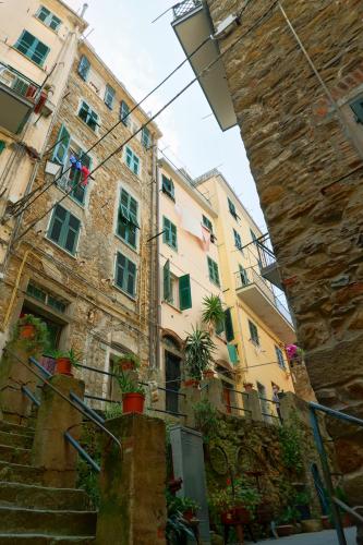 a building with stairs and potted plants in front of it at Rossese in Riomaggiore