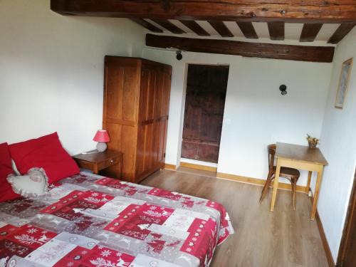a bedroom with a red bed and a wooden floor at Maison de l'Epine -spa- Versant du soleil in Granier