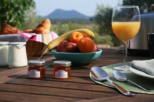 a table with a bowl of fruit and a glass of orange juice at PantaiaHomes - My Little Garden - Piscine - Vue panoramique in Tavernes