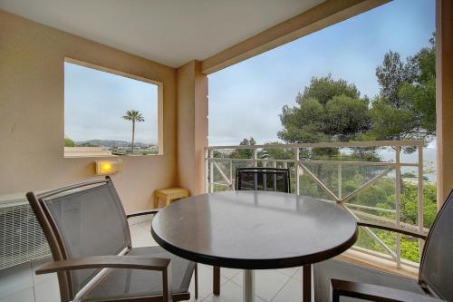 une pièce avec une table et des chaises et une grande fenêtre dans l'établissement IMMOGROOM - 2 Rooms - Renovated - Pool - Air conditioning - Parking - Wifi, à Cannes