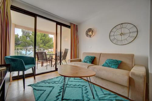 un salon avec un canapé et une table dans l'établissement IMMOGROOM - 2 Rooms - Renovated - Pool - Air conditioning - Parking - Wifi, à Cannes