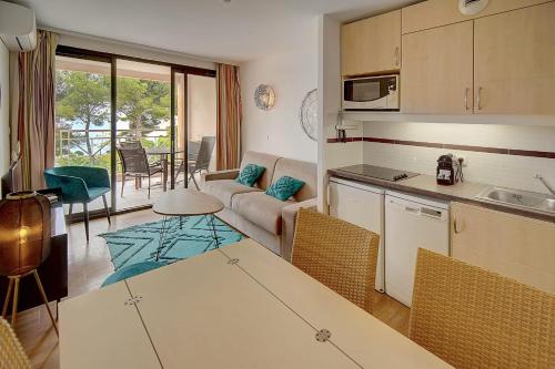 une cuisine et un salon avec un canapé et une table dans l'établissement IMMOGROOM - 2 Rooms - Renovated - Pool - Air conditioning - Parking - Wifi, à Cannes