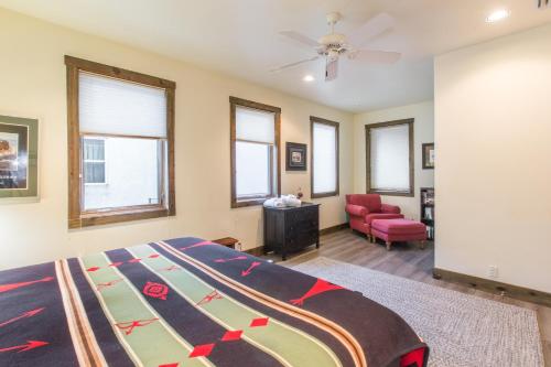 a bedroom with a bed and a chair and windows at Mission Rock 1 in Ouray