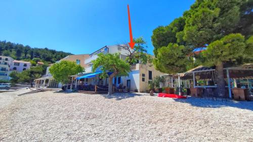 a sandy beach with trees and buildings on it at D&D in Drvenik
