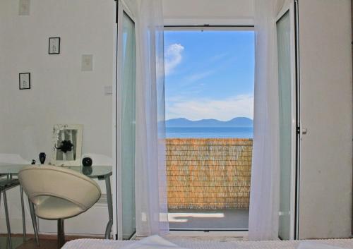 a room with a table and a view of the ocean at D&D in Drvenik