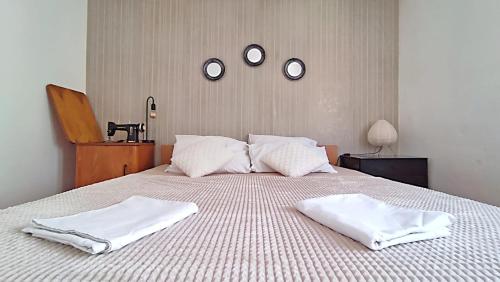 a bed with two white towels on top of it at D&D in Drvenik