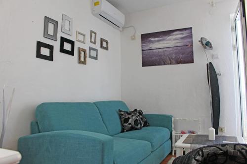 a living room with a blue couch and pictures on the wall at D&D in Drvenik