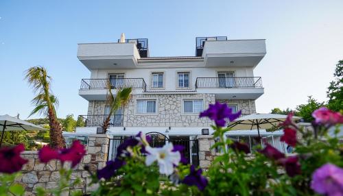 a white building with flowers in front of it at Urla 1867 Hotel in Urla