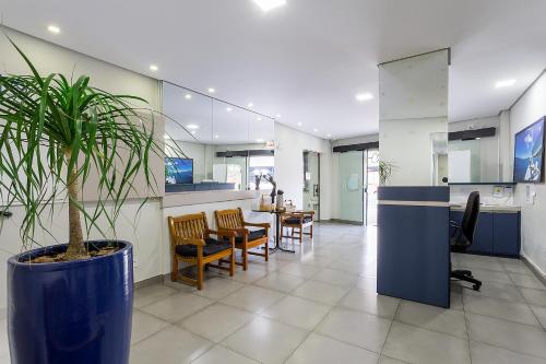 an office with a potted plant in the middle of a lobby at Hotel Marjaí in Itajaí