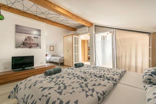 a bedroom with a large bed and a flat screen tv at Hangar Apartments in Izola