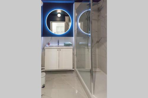 une salle de bain avec une douche, un lavabo et un miroir dans l'établissement Goodserris - Disney Family Apartment, à Serris