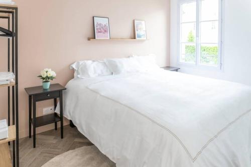 une chambre avec un grand lit blanc et une fenêtre dans l'établissement Goodserris - Disney Family Apartment, à Serris