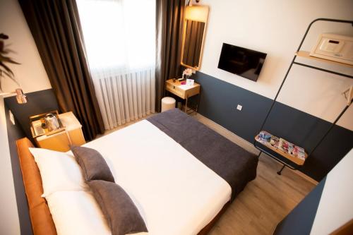 a hotel room with a bed and a television at Urla 1867 Hotel in Urla