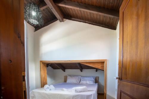 Pokój z łóżkiem z białą pościelą i ręcznikami w obiekcie Τraditional fully detached villa on a luxurious hillock of Thessaloniki with its own garden also for family & wedding gatherings for 10 to 25 people only 15 minutes from airport w Salonikach
