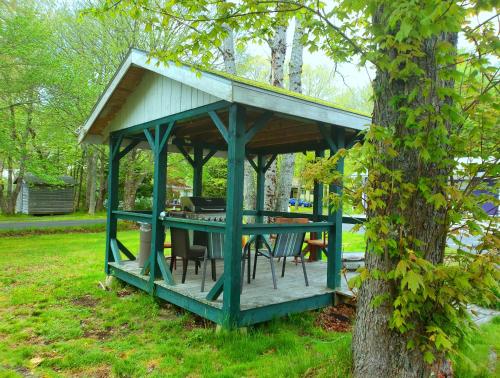 a gazebo with a table and chairs in a tree at Wildwood Motel in Shelburne