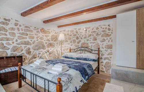 a stone walled bedroom with a bed and a tv at Apartment & Studio Goga in Soline