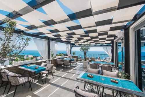a patio with tables and chairs and a view of the ocean at Padam Hotel & SPA in Ulcinj