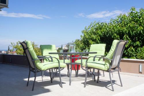a group of chairs and a table on a patio at Τraditional fully detached villa on a luxurious hillock of Thessaloniki with its own garden also for family & wedding gatherings for 10 to 25 people only 15 minutes from airport in Thessaloniki