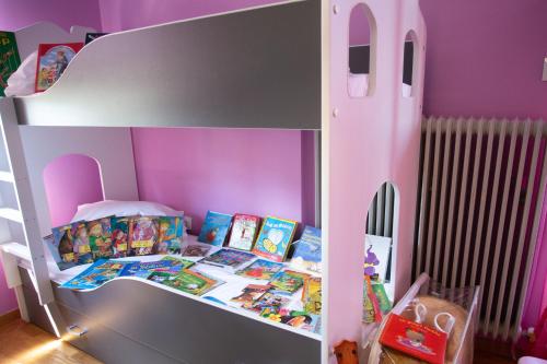 a bunk bed in a pink room with books at Τraditional fully detached villa on a luxurious hillock of Thessaloniki with its own garden also for family & wedding gatherings for 10 to 25 people only 15 minutes from airport in Thessaloniki