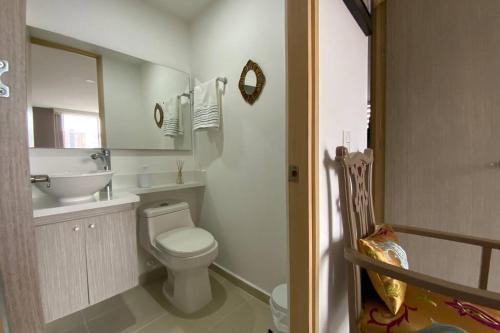 een badkamer met een toilet, een wastafel en een spiegel bij Ubicación privilegiada. Todo al alcance de tu mano in Sabaneta