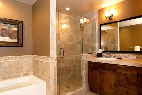 a bathroom with a shower and a sink and a tub at Purgatory Lodge Unit 302 in Durango Mountain Resort