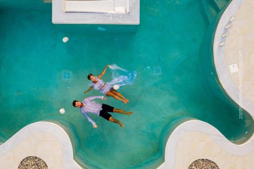 two people are swimming in a swimming pool at Villa Shangri-La Zakinthos in Zakynthos Town