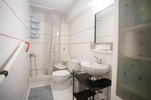 a white bathroom with a toilet and a sink at Traditional villa appartment with garden, also for gatherings ,15 minutes from Thessaloniki airport in Thessaloniki