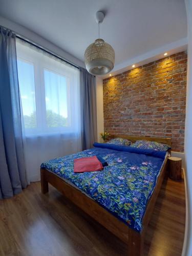 een slaapkamer met een bed en een bakstenen muur bij Koszalin-Old Town Apartment in Koszalin