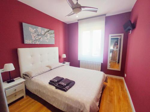 a bedroom with a large bed with purple walls at IDEAL & CENTRO, tranquilo GARAJE GRATIS y 2 baños in Logroño
